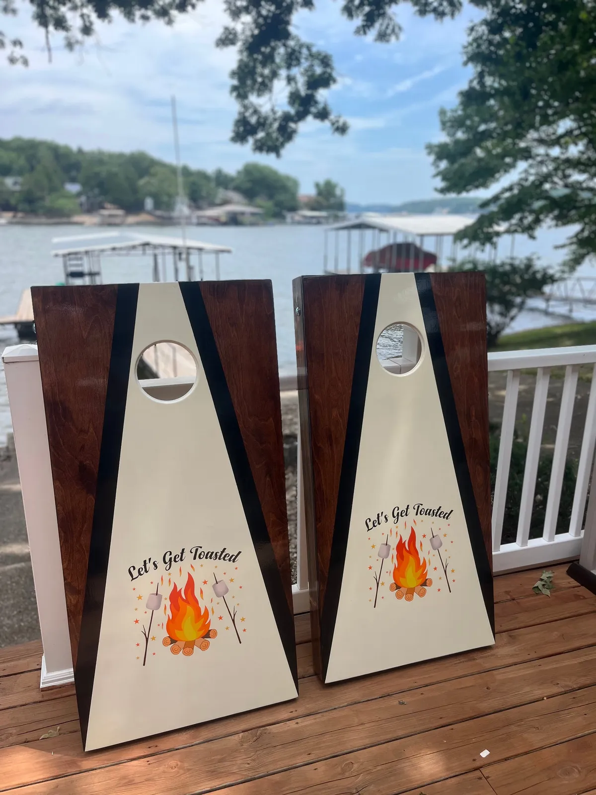 This exterior image spotlights a wooden deck overlooking the lake, complete with cornhole boards for games, and offers a clear view of the water. The atmosphere is playful yet relaxed, ideal for gatherings or casual fun with friends.